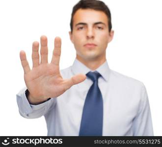 business and office, ban, veto, warning concept - attractive buisnessman making stop gesture