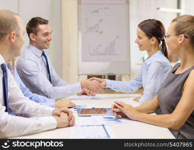 business and office concept - businessman and businesswoman shaking hands in office