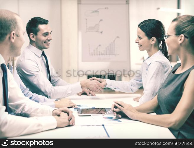 business and office concept - businessman and businesswoman shaking hands in office