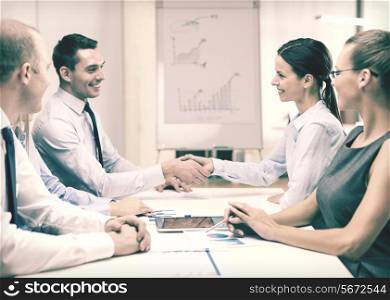business and office concept - businessman and businesswoman shaking hands in office
