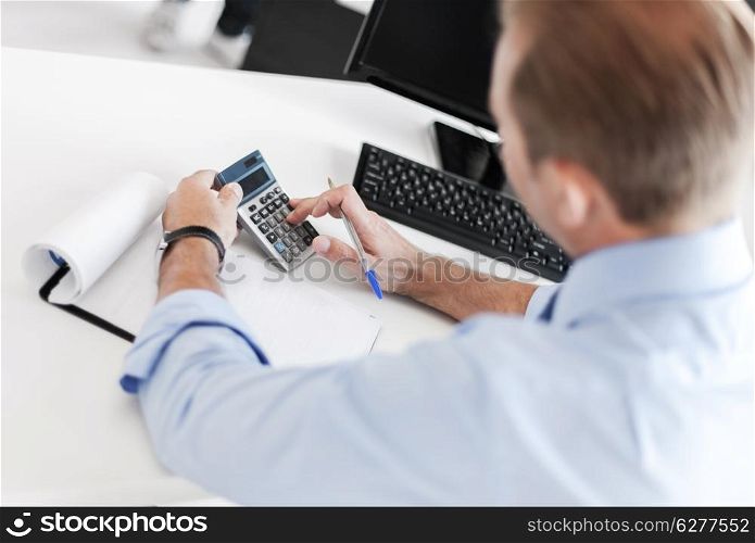 business and office concept - businessman with notebook and calculator
