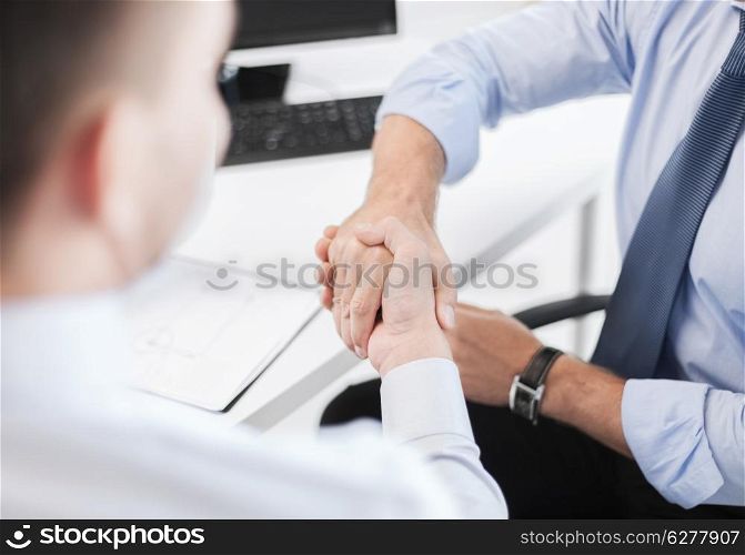business and office concept - businessmen shaking hands in office