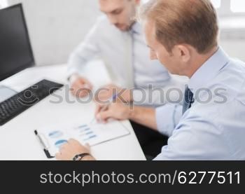 business and office concept - businessmen with notebook on meeting