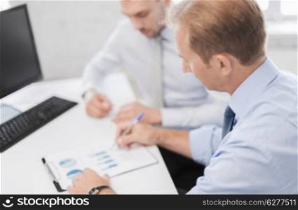 business and office concept - businessmen with notebook on meeting