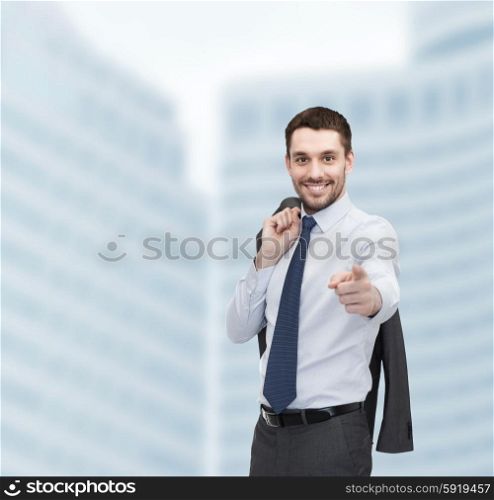 business and office concept - handsome buisnessman with jacket over shoulder pointing finger at you. handsome buisnessman with jacket over shoulder