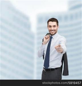business and office concept - handsome buisnessman with jacket over shoulder pointing finger at you. handsome buisnessman with jacket over shoulder