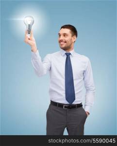 business and office concept - handsome businessman holding light bulb