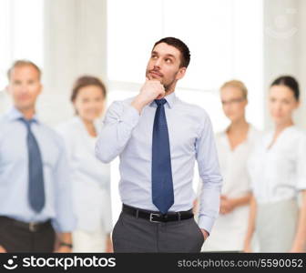 business and office concept - handsome businessman looking up