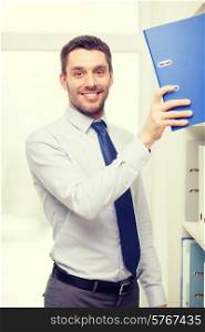 business and office concept - handsome businessman picking folder at office