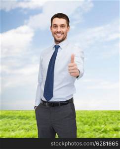 business and office concept - handsome businessman showing thumbs up