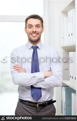 business and office concept - handsome businessman with crossed arms at office