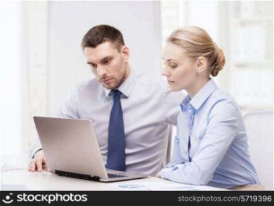 business and office concept - serious business team working with laptop computer in office