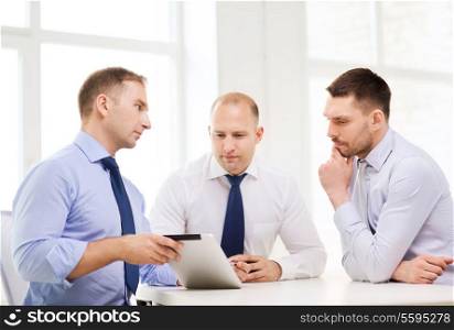 business and office concept - serious business team working with tablet pc computer in office