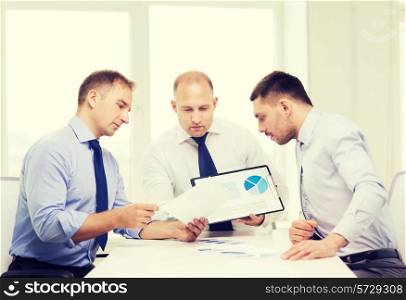 business and office concept - serious businessman showing others charts in office