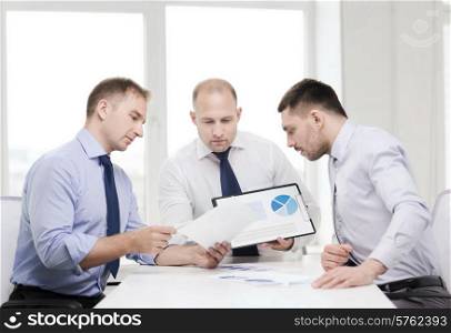 business and office concept - serious businessman showing others charts in office