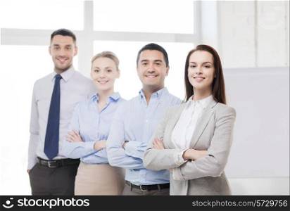 business and office concept - smiling beautiful businesswoman with crossed hands and team in office