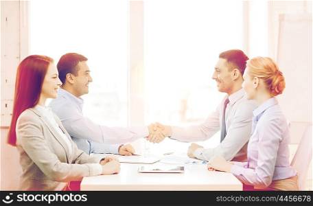 business and office concept - smiling business team having meeting in office. business team having meeting in office