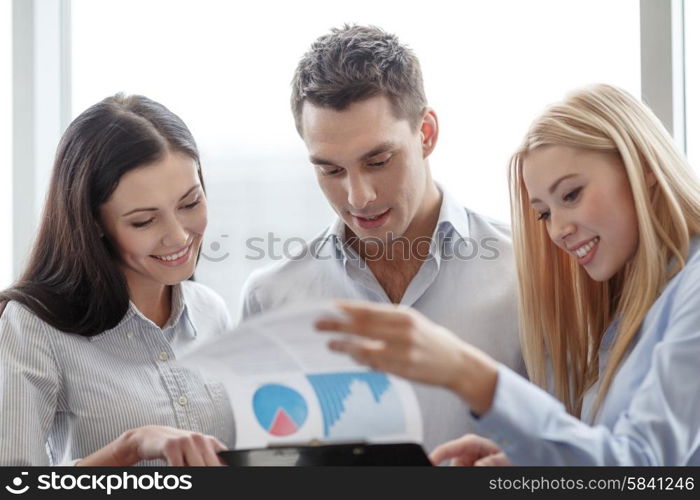 business and office concept - smiling business team looking at clipboard