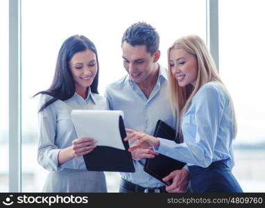 business and office concept - smiling business team looking at clipboard. business team looking at clipboard