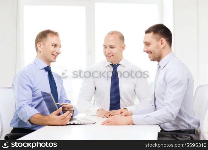 business and office concept - smiling business team working with laptop computer in office