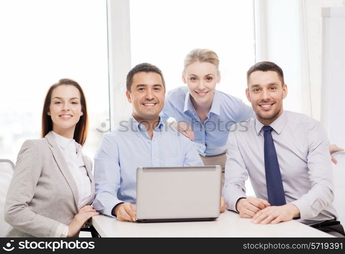 business and office concept - smiling business team working with laptop computer in office