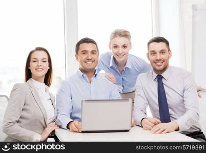 business and office concept - smiling business team working with laptop computer in office