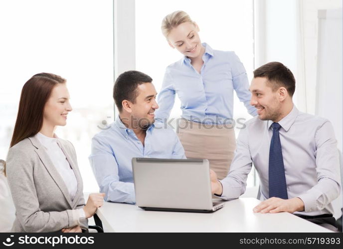 business and office concept - smiling business team working with laptop computer in office