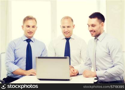 business and office concept - smiling business team working with laptop computer in office