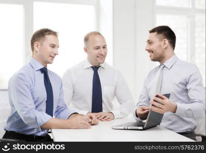 business and office concept - smiling business team working with laptop computer in office