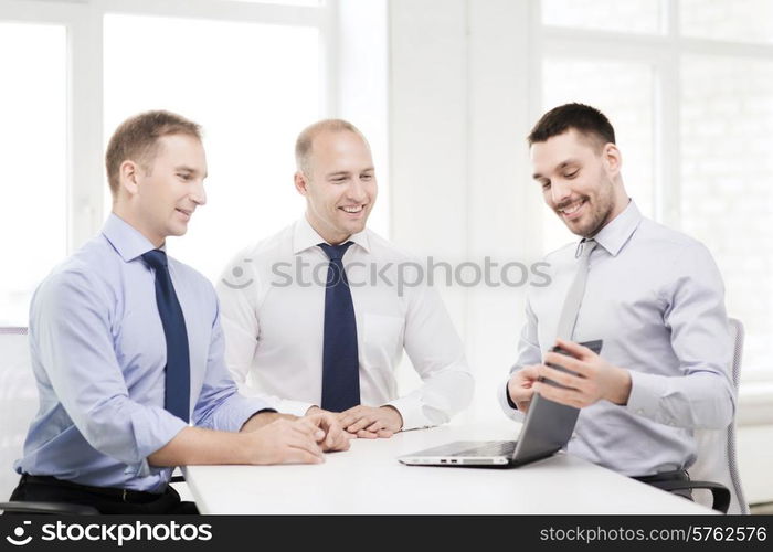 business and office concept - smiling business team working with laptop computer in office