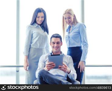 business and office concept - smiling business team working with tablet pc in office. business team working with tablet pc in office