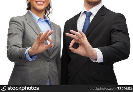 business and office concept - smiling businessman and businesswoman showing ok sign