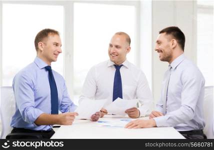 business and office concept - smiling businessmen with papers in office