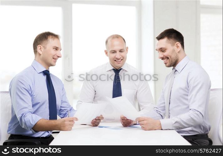 business and office concept - smiling businessmen with papers in office