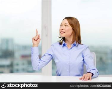 business and office concept - smiling businesswoman pointing finger up in office