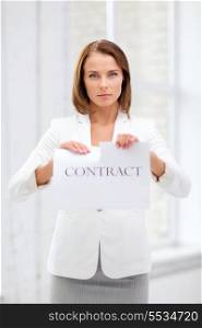business and office, legal concept - concentrated businesswoman tearing contract in office