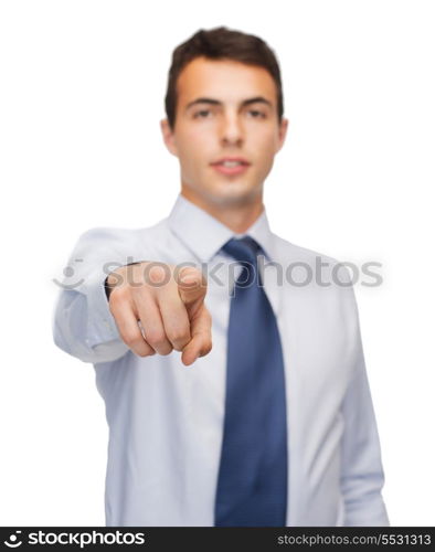 business and office, people concept - friendly young buisnessman pointing finger