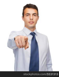 business and office, people concept - friendly young buisnessman pointing finger