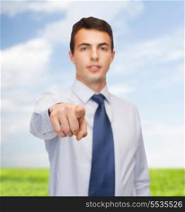 business and office, people concept - friendly young buisnessman pointing finger