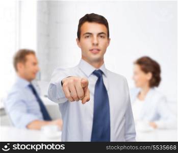 business and office, people concept - friendly young buisnessman pointing finger
