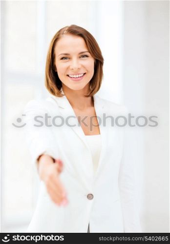 business and partnership concept - businesswoman with an open hand ready for handshake