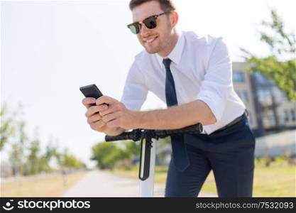 business and people and concept - close up of young businessman with smartphone and electric scooter outdoors. businessman with smartphone and electric scooter