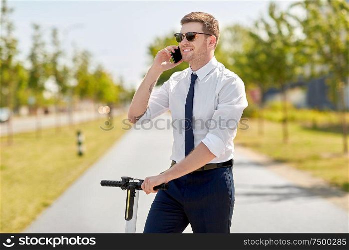 business and people and concept - young businessman calling on smartphone and electric scooter in city. businessman with scooter calling on smartphone