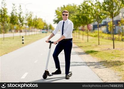 business and people and concept - young businessman riding electric scooter in city. young businessman riding electric scooter in city