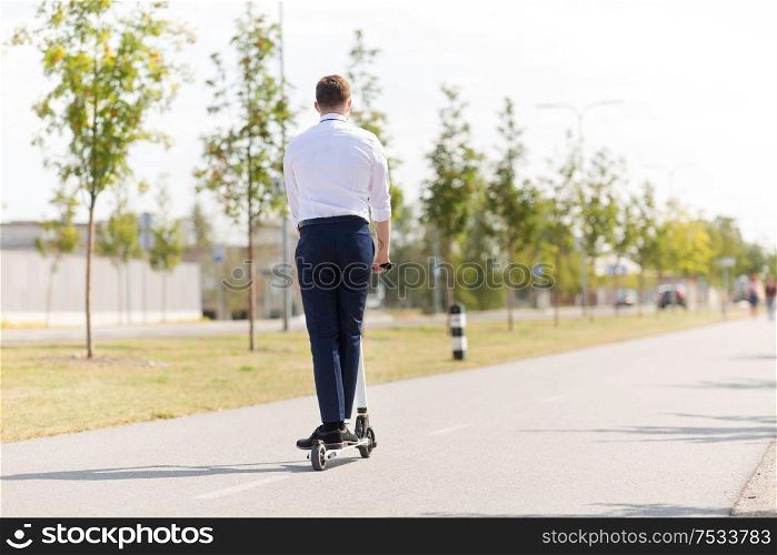 business and people and concept - young businessman riding electric scooter outdoors. young businessman riding electric scooter outdoors