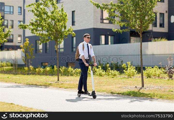 business and people and concept - young businessman with backpack riding electric scooter. businessman with backpack riding electric scooter