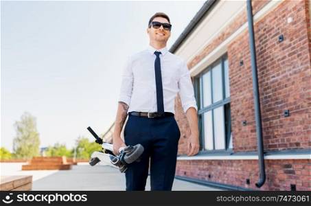 business and people and concept - young businessman with folding scooter on rooftop. businessman with folding scooter on rooftop