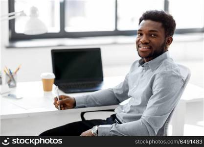 business and people concept - african american businessman with pen sitting at office table. african american businessman with pen at office. african american businessman with pen at office