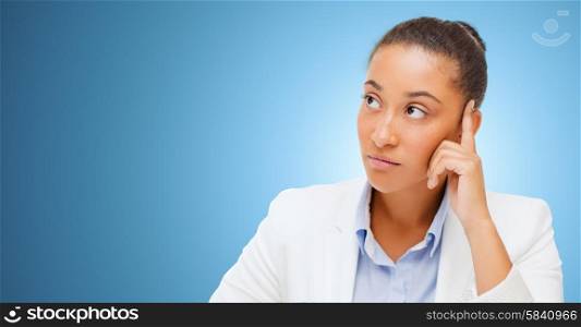 business and people concept - african american businesswoman looking up and thinking over blue background. african businesswoman looking up and thinking