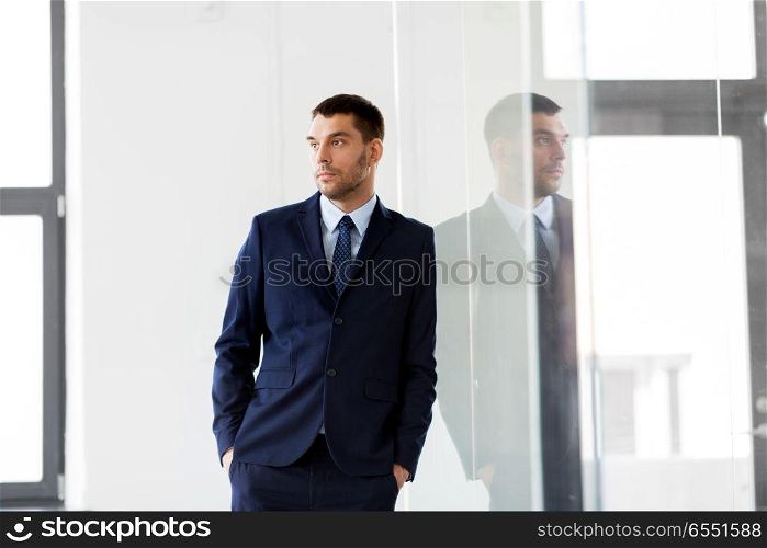 business and people concept - businessman at office glass wall. businessman at office glass wall. businessman at office glass wall